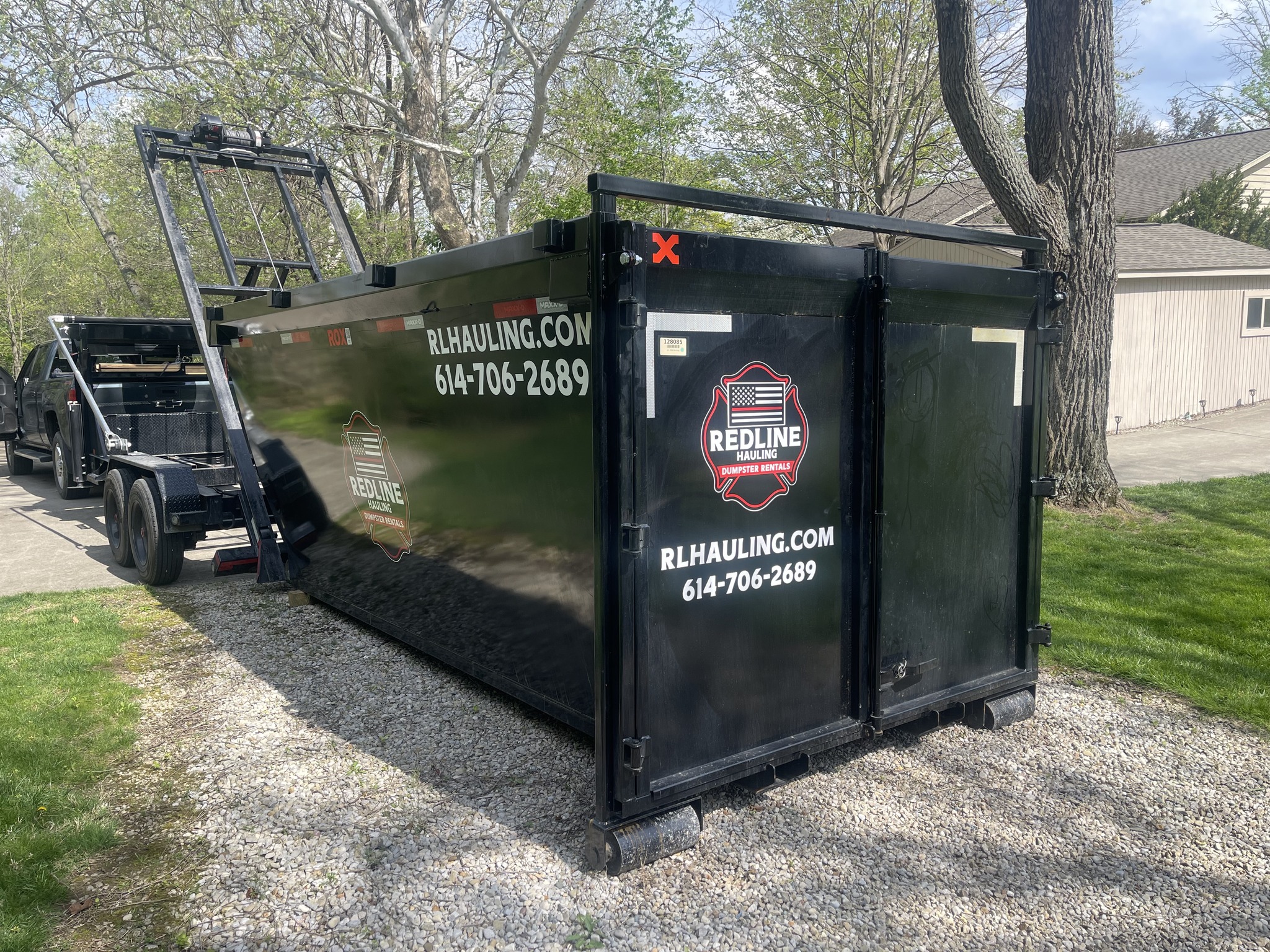 Redline Hauling red Peterbilt roll-off truck delivering dumpster in Westerville Ohio