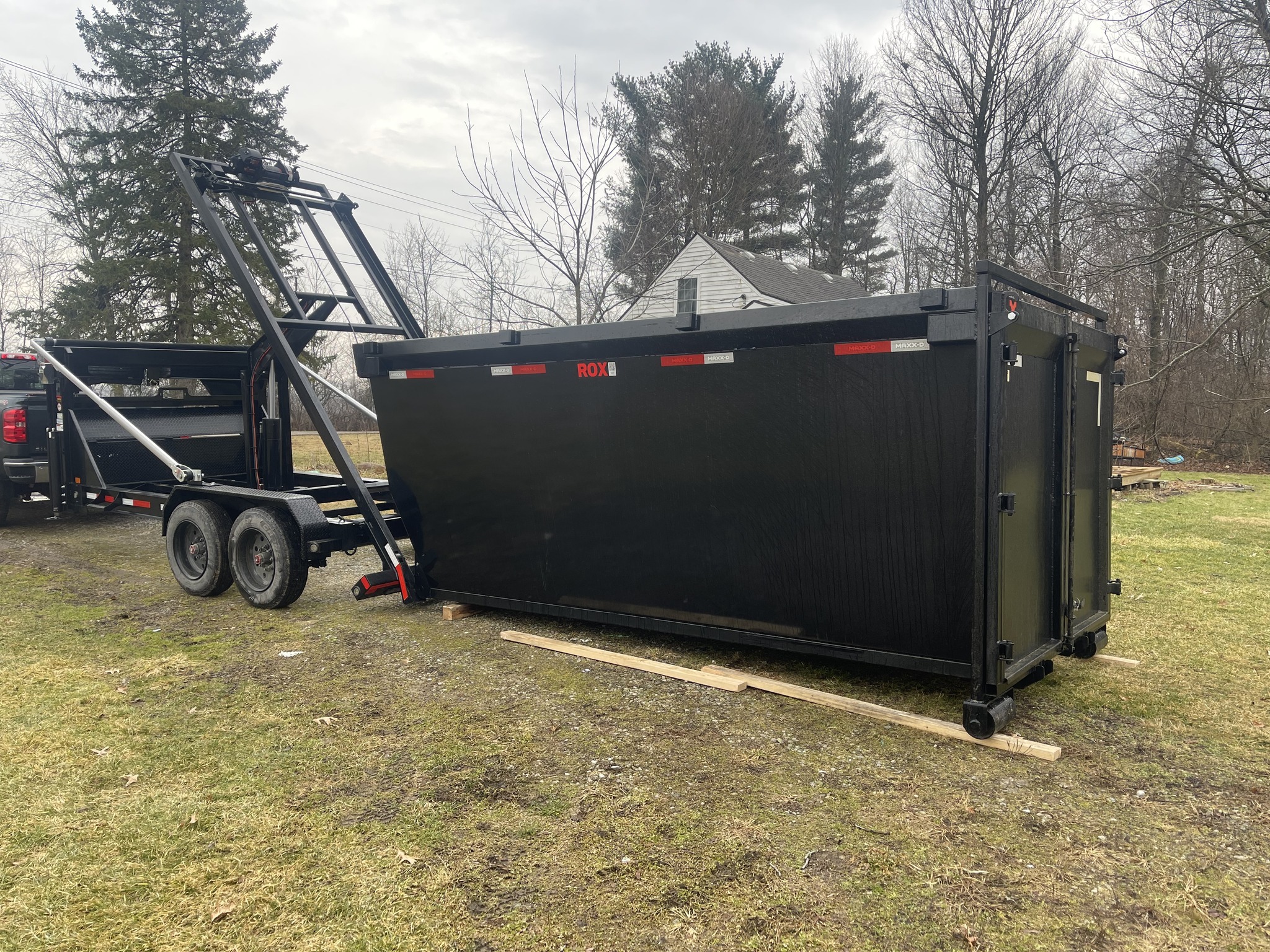 Redline Hauling red roll-off truck staged for Knox County Ohio commercial delivery